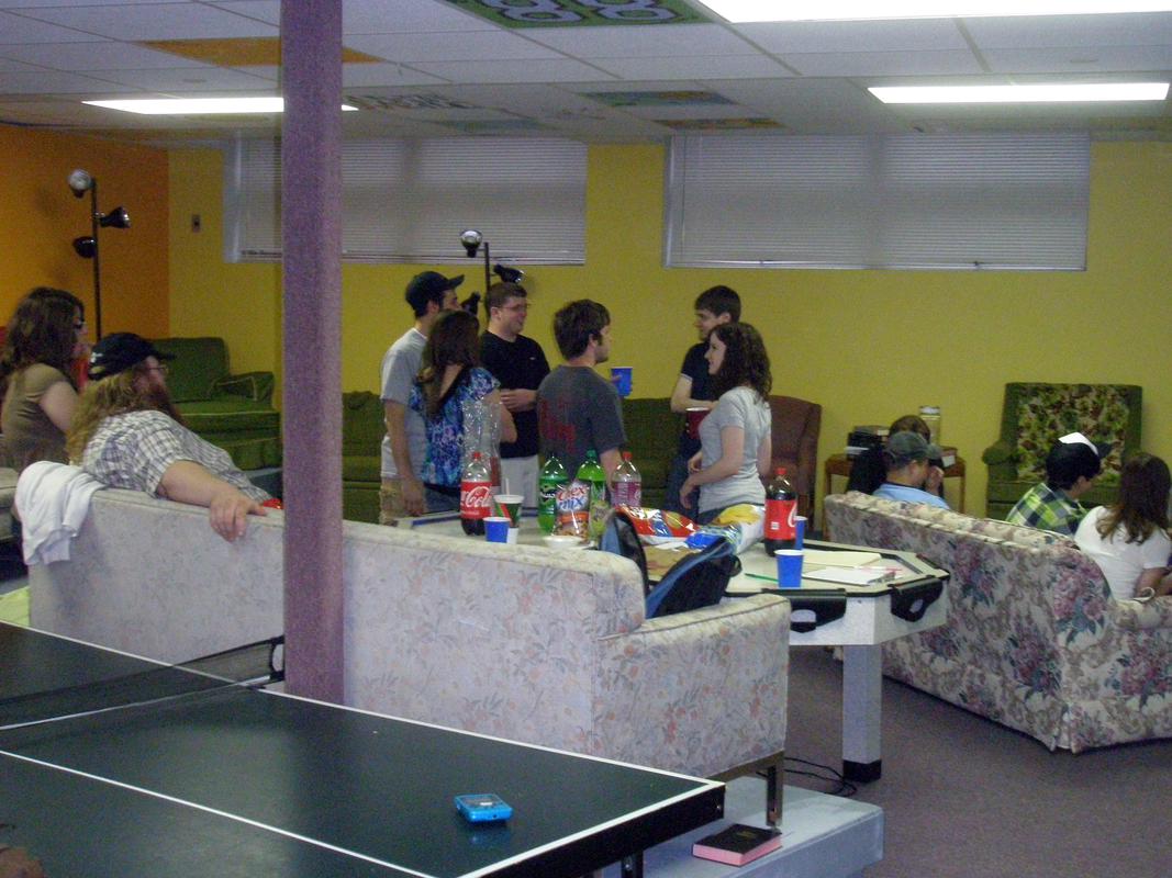 Numerous players discuss strategies while players on the far right play a match. This is the best shot Tyler has of the “tiered” area, with couches on platforms of various heights for easy viewing