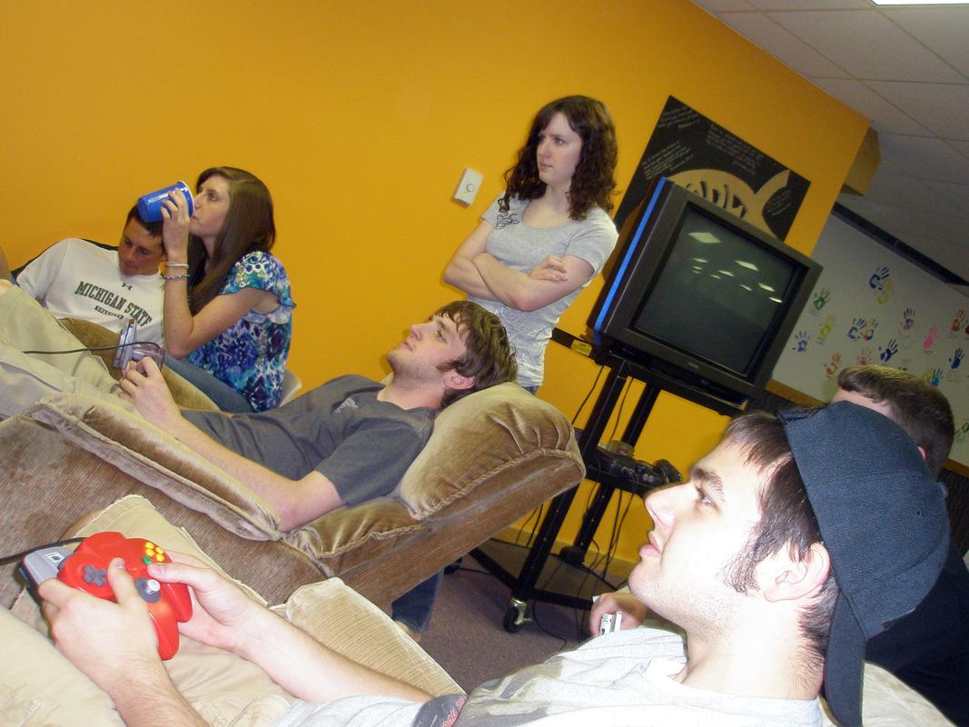 Rick (far left) makes some late team changes on Game Boy Color, while Laura (seated) and Bailey (standing) watch Conner (center) and Tyler play their first match