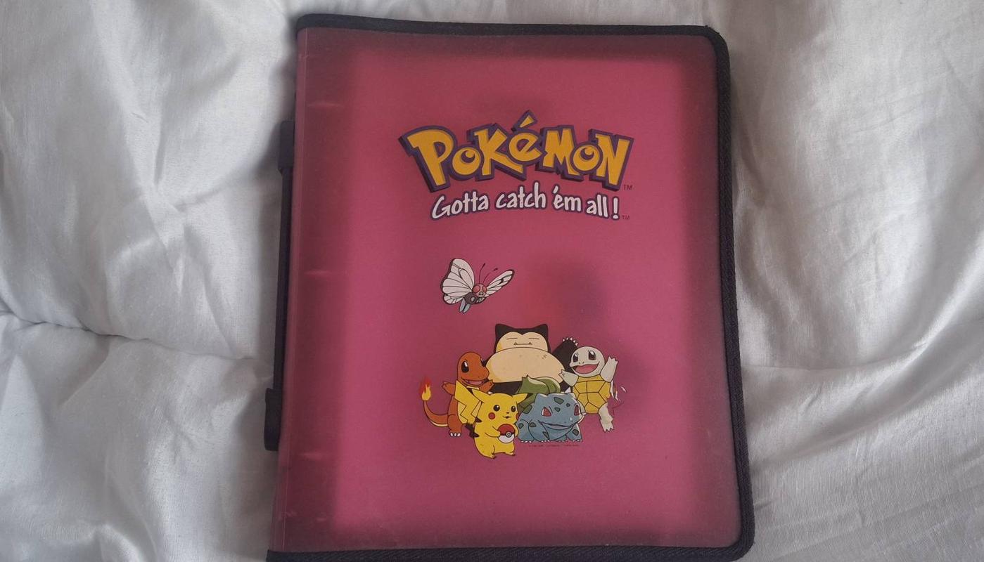 The front of Adam’s Pokémon TCG folder, featuring a picture of Snorlax, Charmander, Pikachu, Bulbasaur, Squirtle, and Butterfree